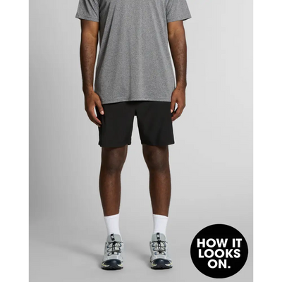 Man wearing gray shirt and black shorts.